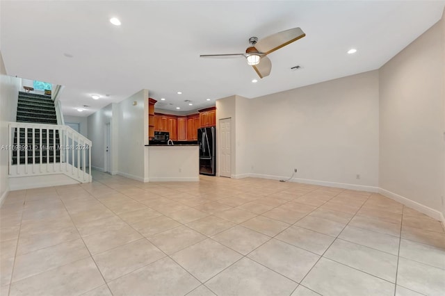 unfurnished living room with light tile patterned floors and ceiling fan