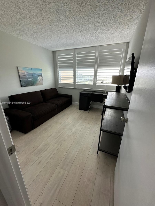 living room with a textured ceiling and light wood-type flooring