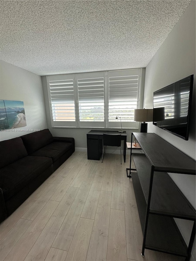 living room featuring a textured ceiling and light hardwood / wood-style flooring