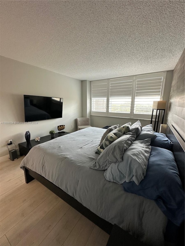 bedroom featuring light wood-type flooring and a textured ceiling