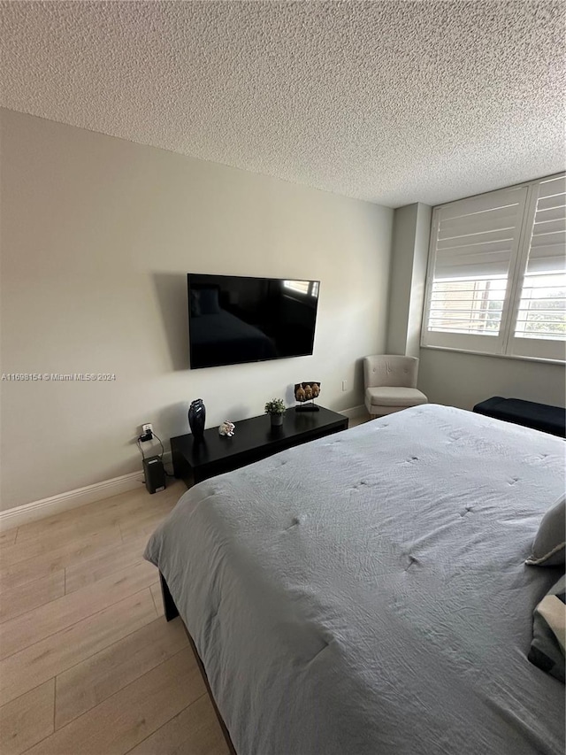 bedroom featuring light hardwood / wood-style flooring and a textured ceiling