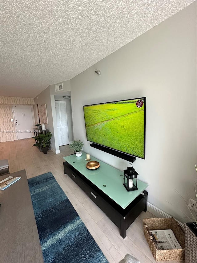 living room featuring a textured ceiling and light hardwood / wood-style floors