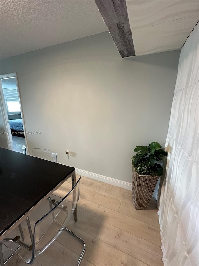 dining area featuring a textured ceiling and light wood-type flooring