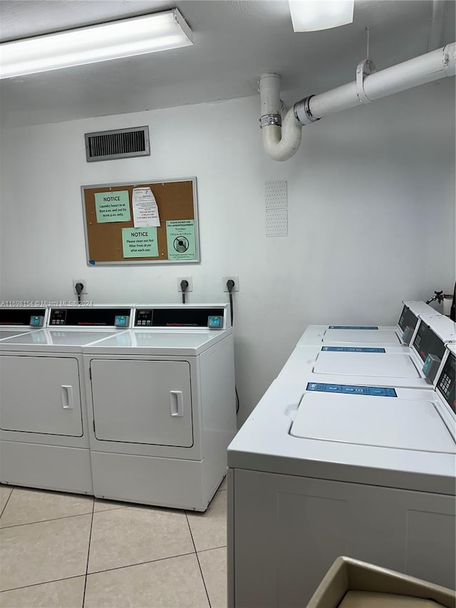 laundry area featuring washer and clothes dryer and light tile patterned floors