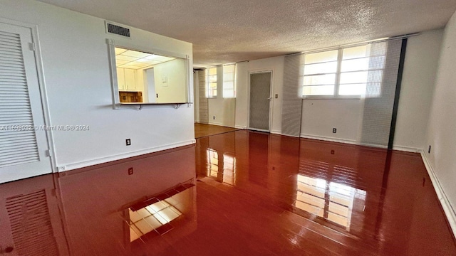 unfurnished room featuring wood-type flooring and a textured ceiling