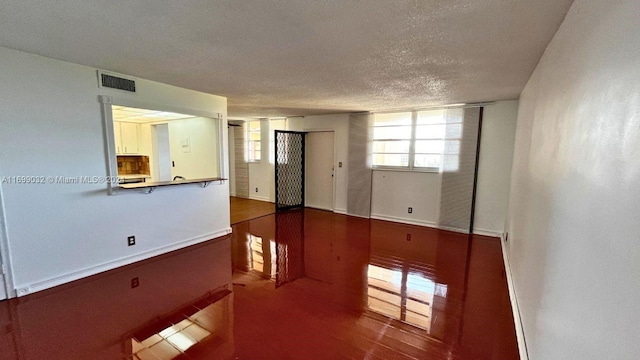 spare room featuring wood-type flooring and a textured ceiling