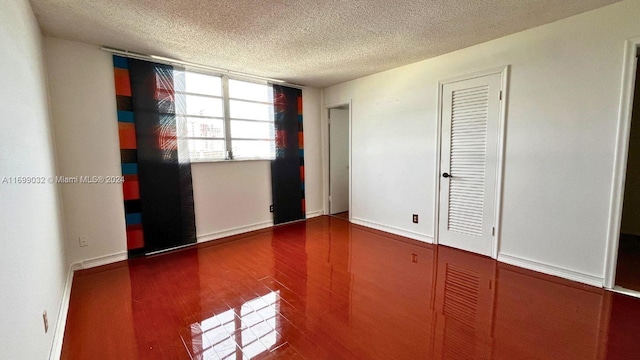 unfurnished bedroom featuring hardwood / wood-style floors and a textured ceiling