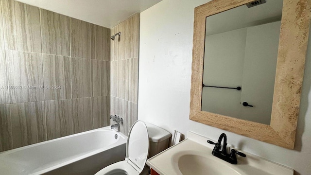 full bathroom with vanity, toilet, and tiled shower / bath