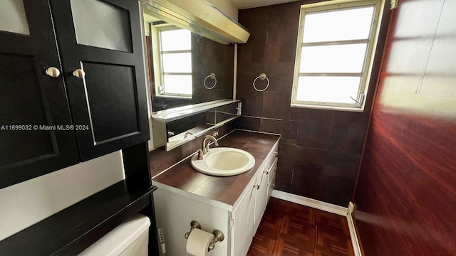 bathroom featuring toilet, parquet flooring, and a wealth of natural light