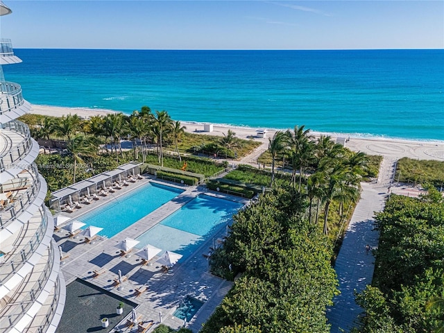 birds eye view of property featuring a water view and a beach view