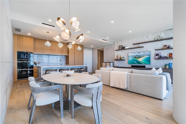 dining room with light hardwood / wood-style floors and an inviting chandelier