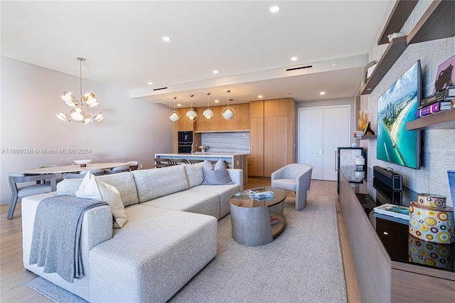 living room featuring light wood-type flooring and an inviting chandelier