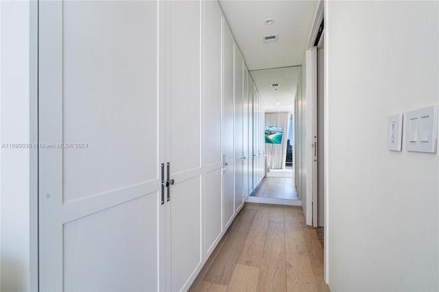 corridor with light hardwood / wood-style floors