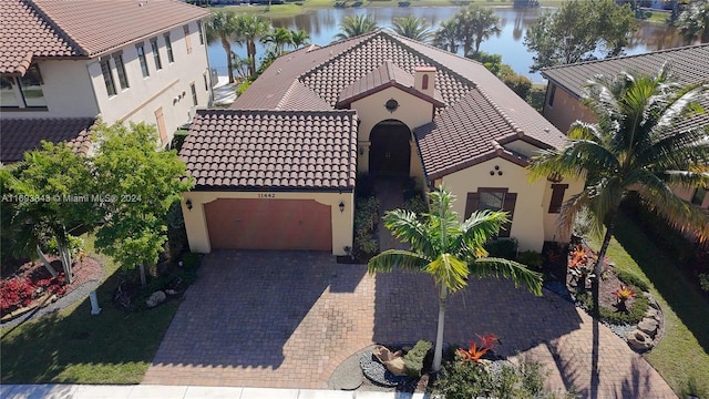 mediterranean / spanish-style house featuring a water view and a garage