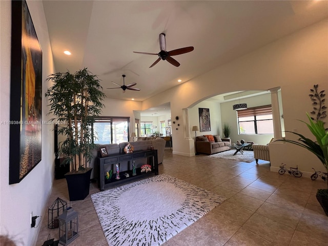 tiled living room featuring ceiling fan and lofted ceiling