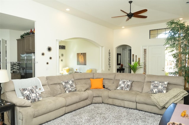 living room with a towering ceiling and ceiling fan