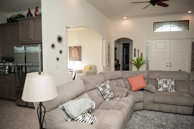 living room featuring a towering ceiling and ceiling fan