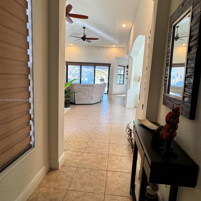 corridor featuring light tile patterned floors and decorative columns