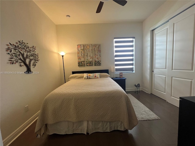 bedroom with ceiling fan, dark wood-type flooring, and a closet