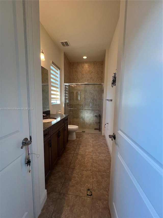 bathroom with walk in shower, tile patterned flooring, vanity, and toilet