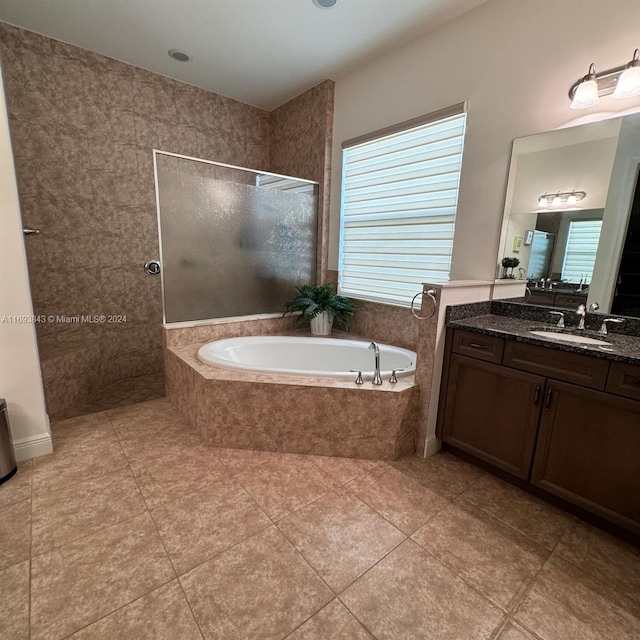 bathroom featuring plus walk in shower, vanity, and tile patterned flooring