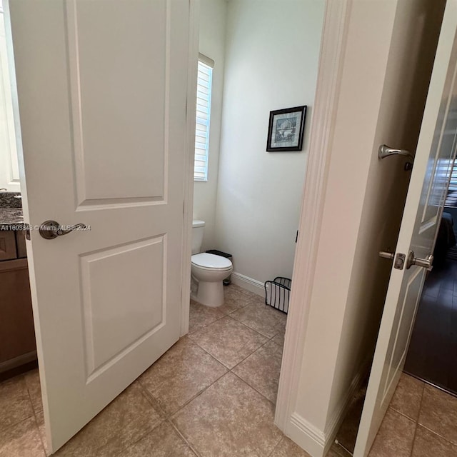 bathroom featuring tile patterned flooring, vanity, and toilet