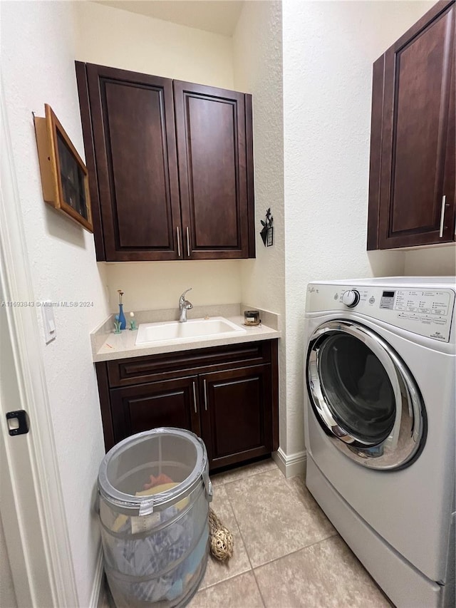 washroom featuring washer / clothes dryer, sink, light tile patterned flooring, and cabinets