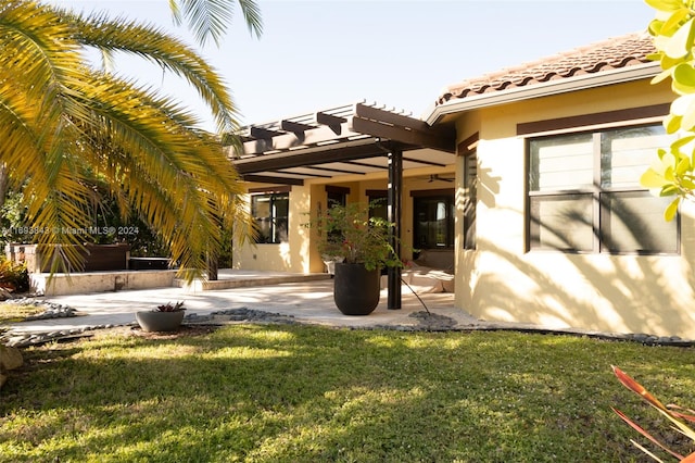 rear view of property with a lawn, a pergola, and a patio