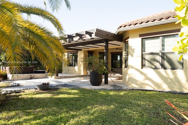 rear view of house with a yard, a patio, and a pergola