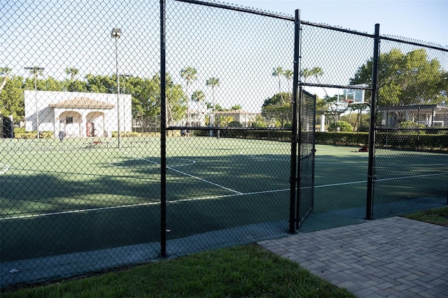 view of tennis court with basketball hoop