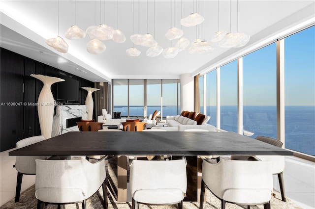 dining room with tile patterned floors, a wealth of natural light, and a water view