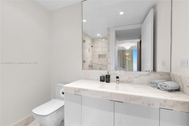 bathroom featuring a shower with door, vanity, and toilet