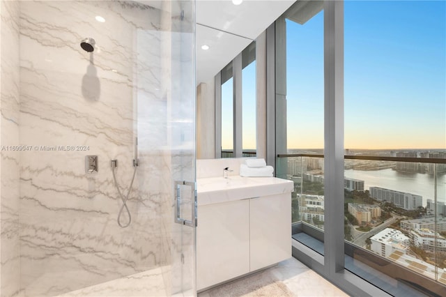 bathroom featuring an enclosed shower, vanity, and a water view