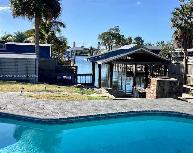 view of swimming pool featuring a yard and a water view