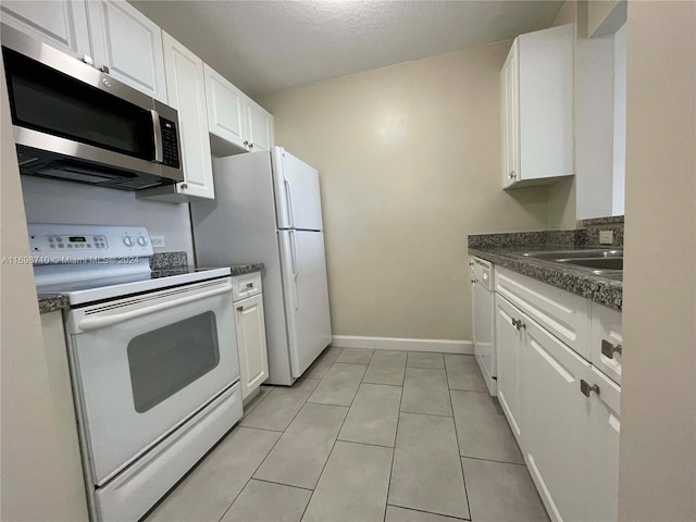 kitchen featuring white cabinets, white appliances, sink, and light tile patterned floors