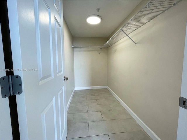 walk in closet with light tile patterned floors