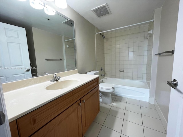 full bathroom with tile patterned floors, vanity, tiled shower / bath combo, and toilet