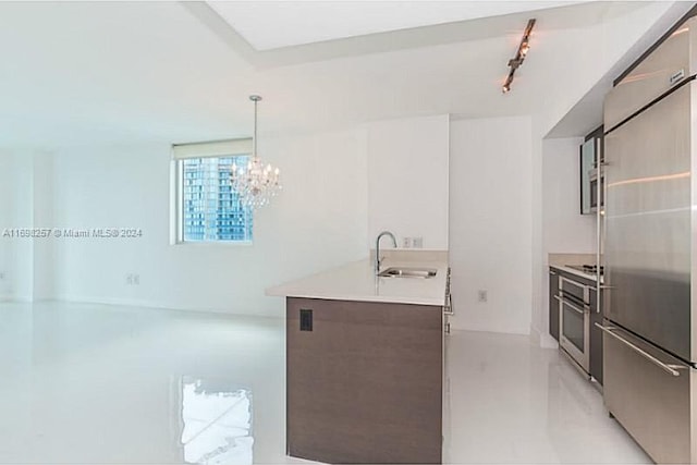 kitchen with a chandelier, decorative light fixtures, stainless steel appliances, and sink