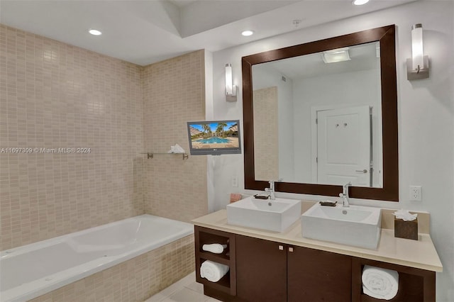 bathroom featuring tile patterned floors, vanity, and tiled tub