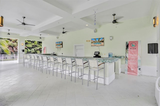 interior space featuring beamed ceiling, ceiling fan, light stone countertops, and coffered ceiling