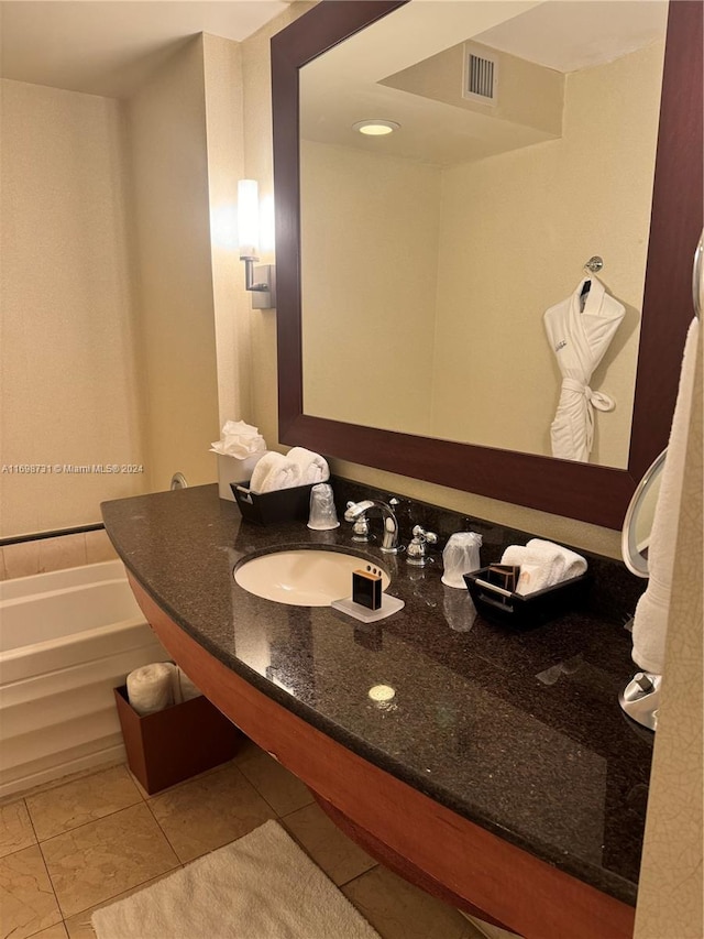 bathroom featuring tile patterned floors, a tub to relax in, and sink