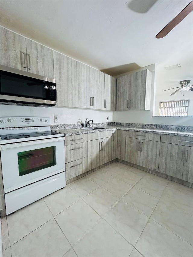 kitchen featuring light brown cabinets, electric stove, sink, and light tile patterned floors