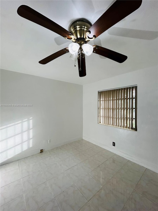 tiled spare room featuring ceiling fan