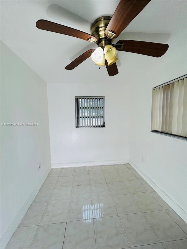 unfurnished room with light tile patterned floors and ceiling fan