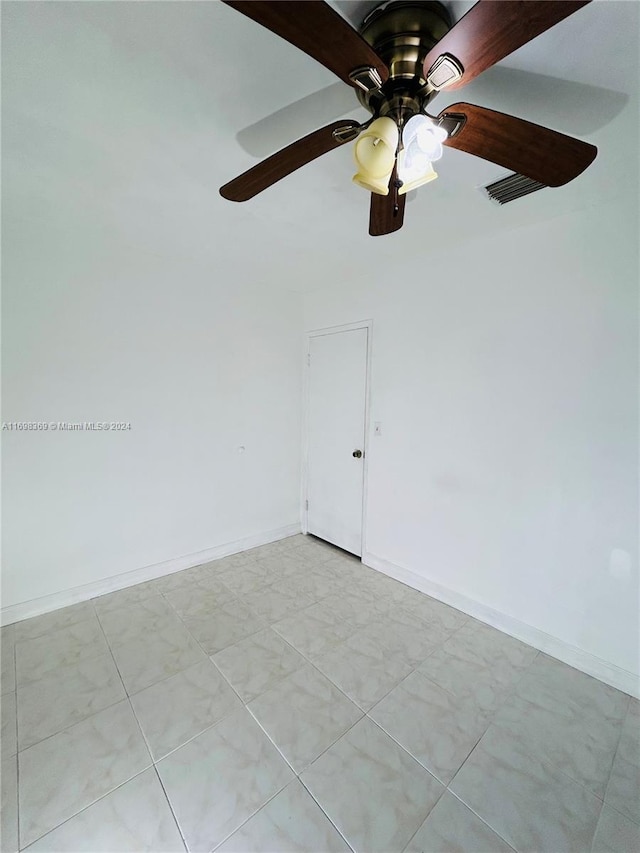 spare room with light tile patterned floors and ceiling fan