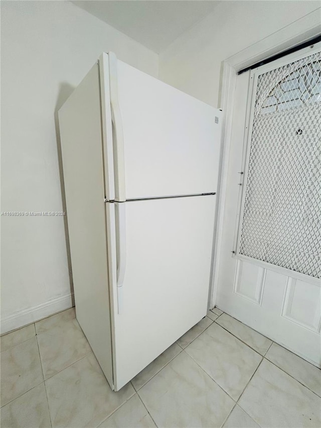 kitchen featuring white cabinets, white fridge, and light tile patterned floors