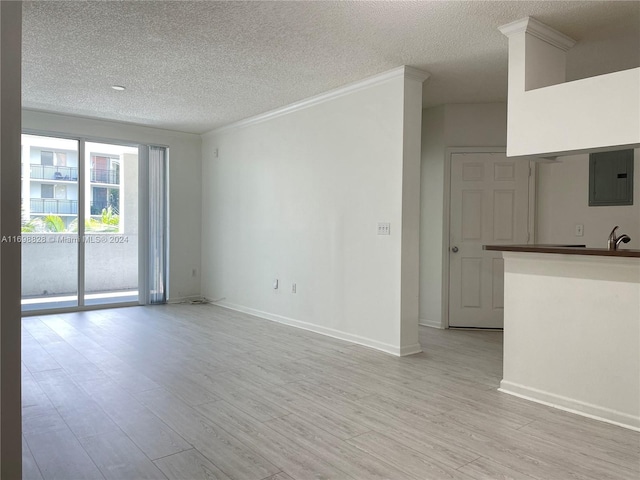 unfurnished living room featuring electric panel, crown molding, light hardwood / wood-style flooring, and a textured ceiling