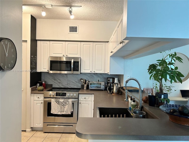 kitchen with white cabinetry, light tile patterned floors, a textured ceiling, and appliances with stainless steel finishes