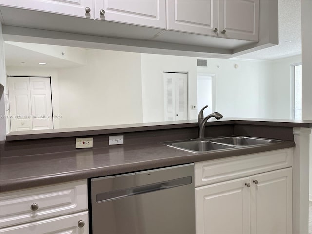 kitchen with dishwasher, a textured ceiling, white cabinetry, and sink