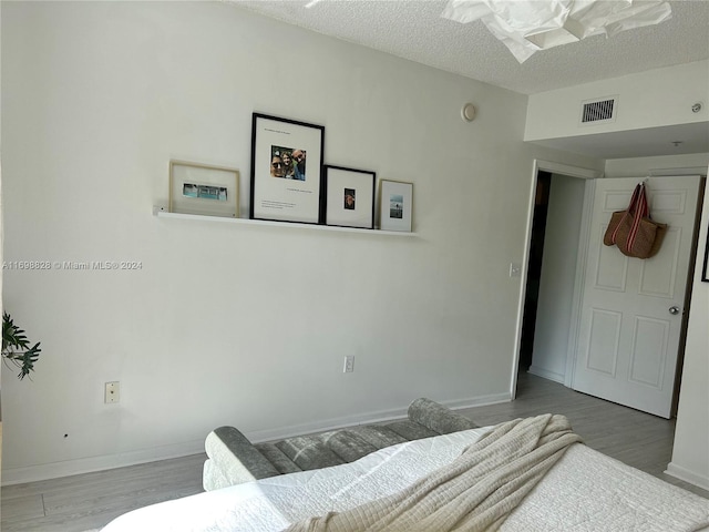 bedroom featuring wood-type flooring and a textured ceiling